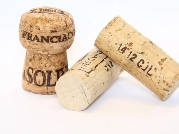 Bouchons de vin en liège naturel posés sur fond blanc, matériau écologique et léger