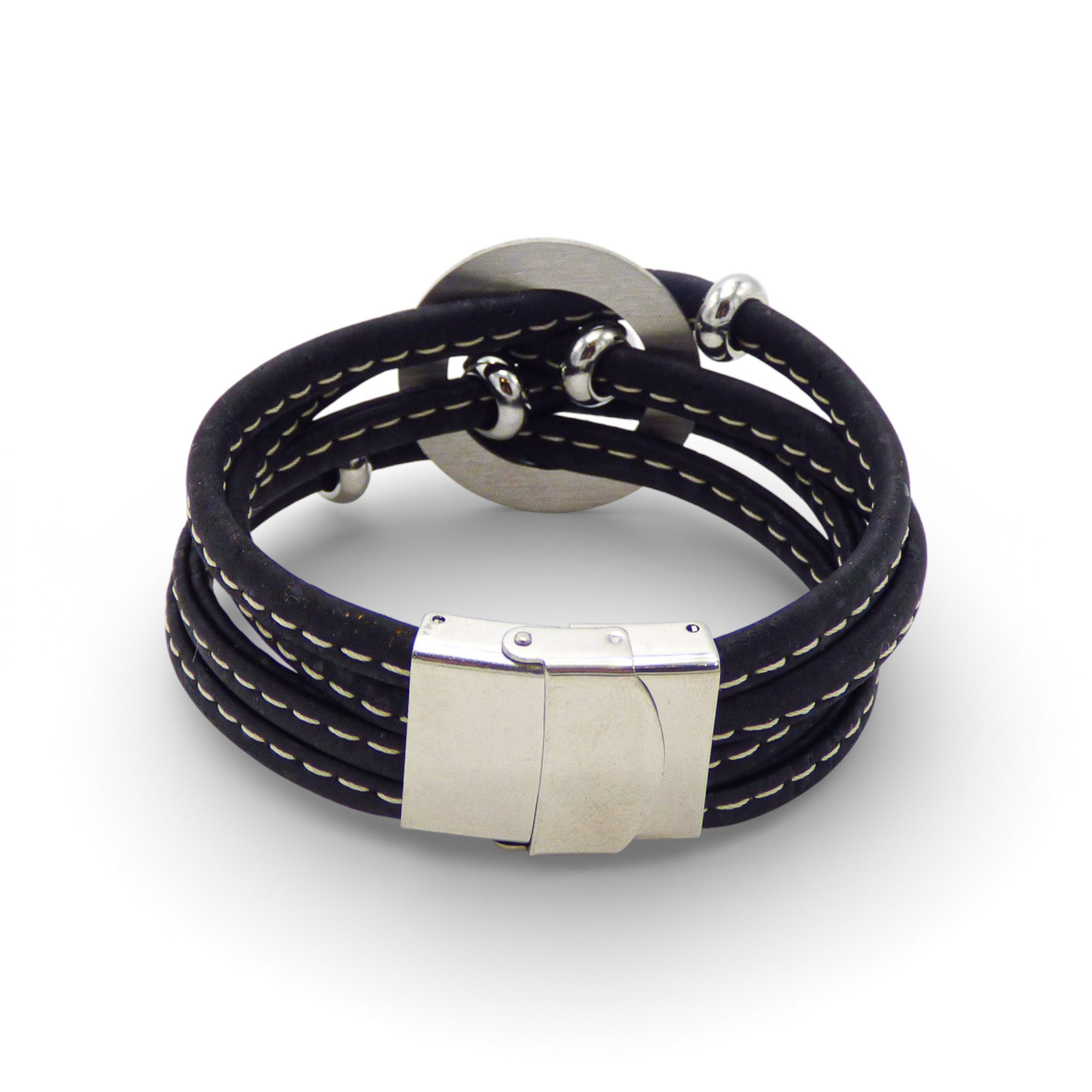 Multi-layered medallion bracelet by Cork Colors featuring a central charm and a silver clasp on a black cork background.