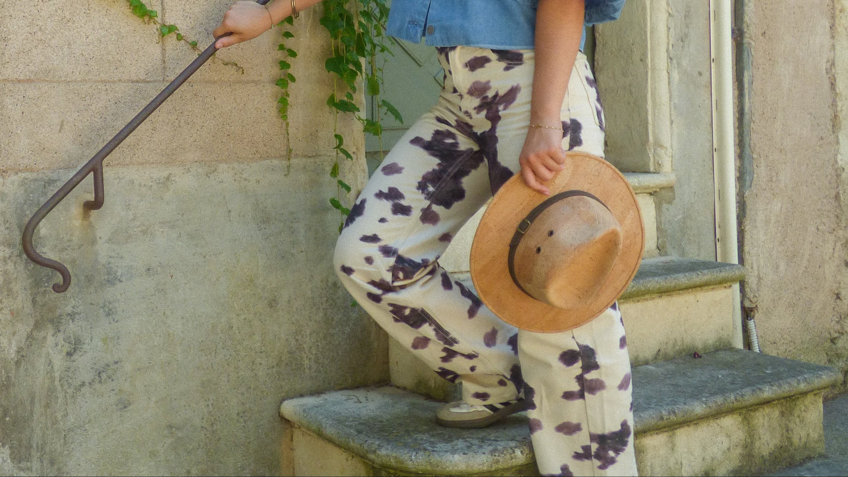 Chapeau cowboy en liège naturel tenu à la main par une femme descendant un escalier en pierre — Amador Varum, Portugal