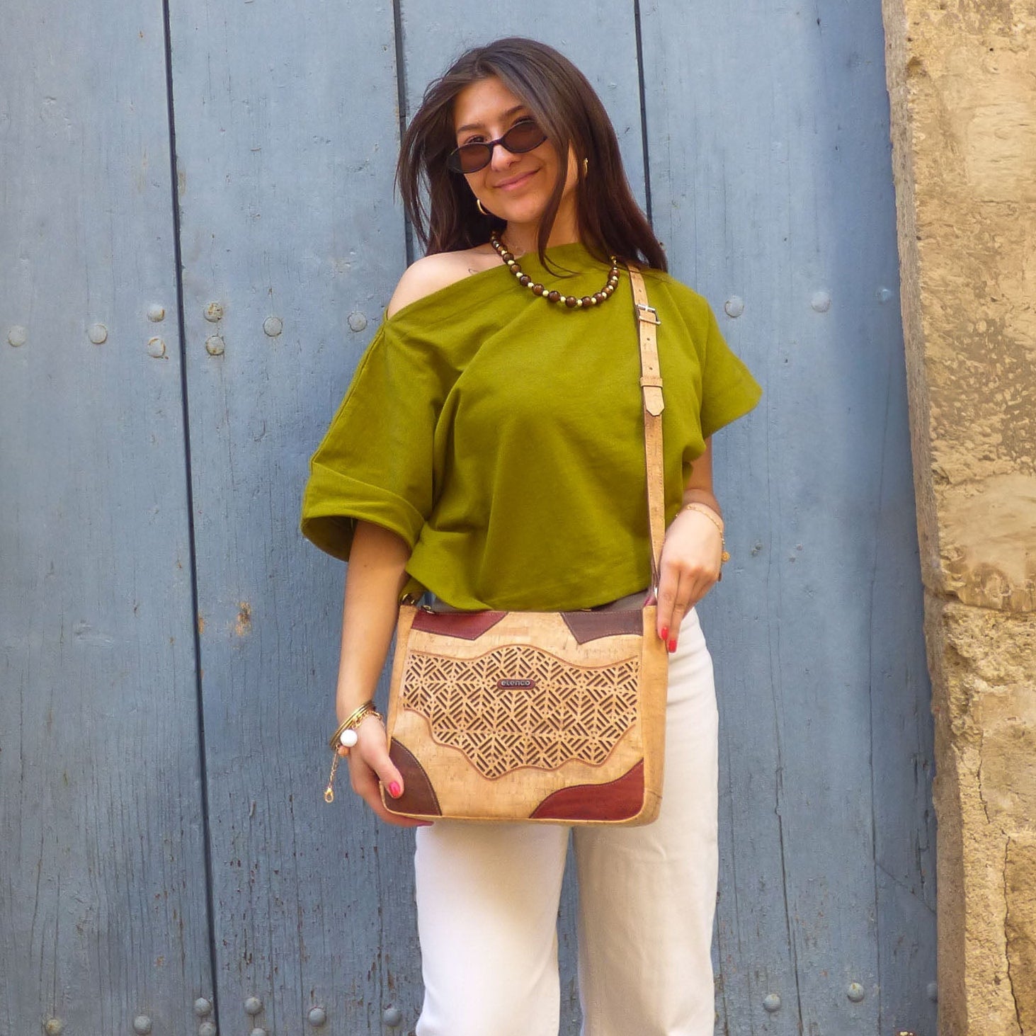 Sac bandoulière en liège aux motifs géométriques colorés, porté à l'épaule pour l'été