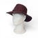 Chapeau cowboy en liège teinté bordeaux porté de profil — Amador Varum, large bord et œillets, Portugal