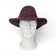 Chapeau cowboy en liège teinté bordeaux porté de face sur buste — Amador Varum, large bord, Portugal