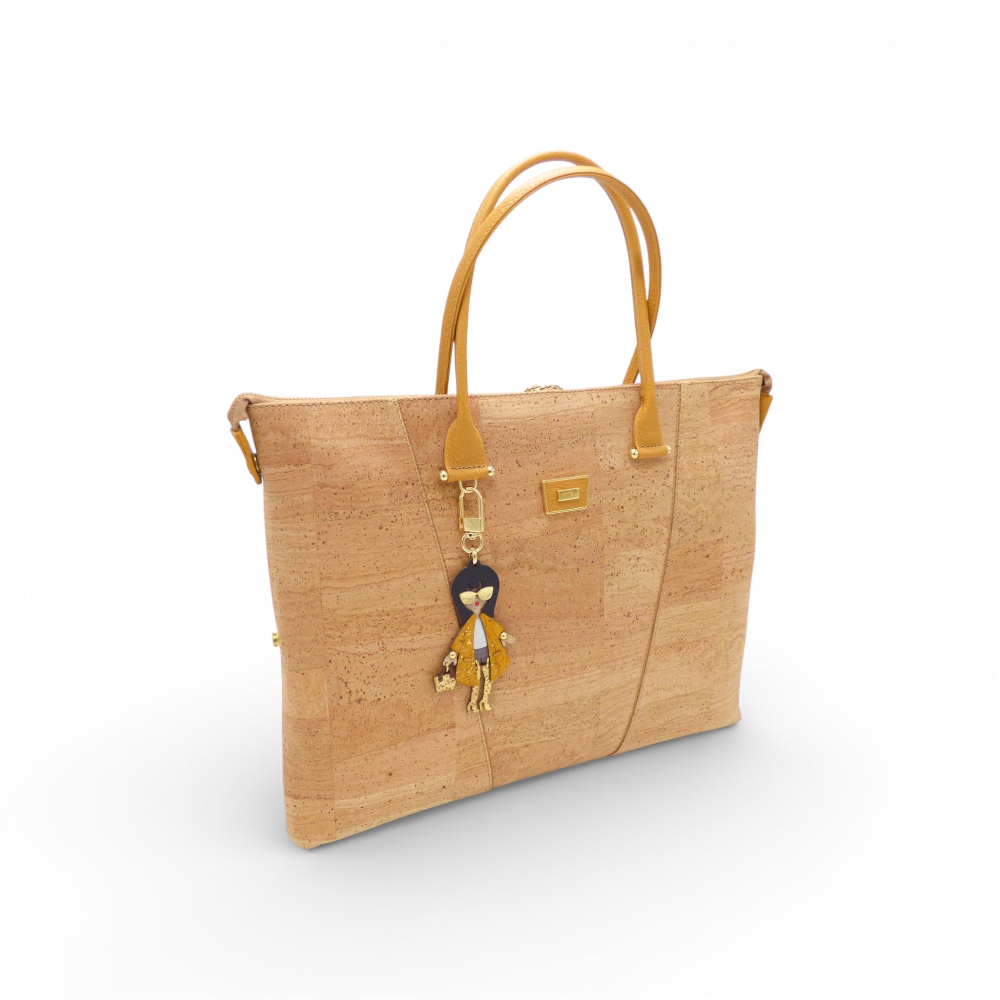 Sac modulable en liège naturel vu de trois-quarts, charm poupée — Artipel, anses camel, Portugal