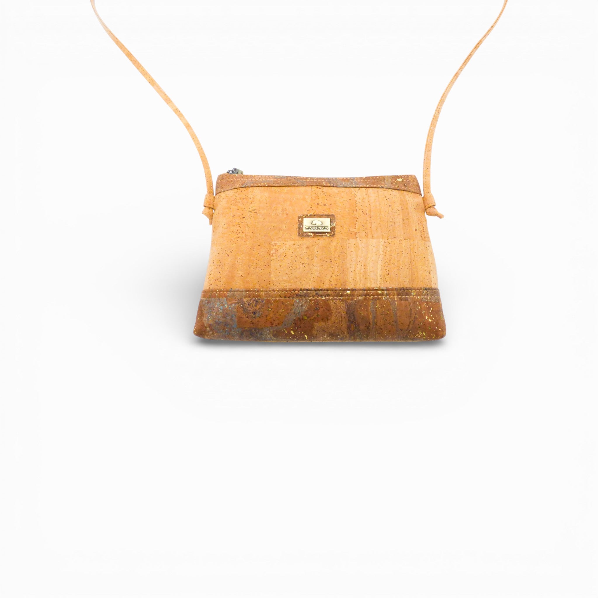 Face d'une pochette bandoulière en liège naturel — Montado, plaque logo, base mouchetée, Portugal