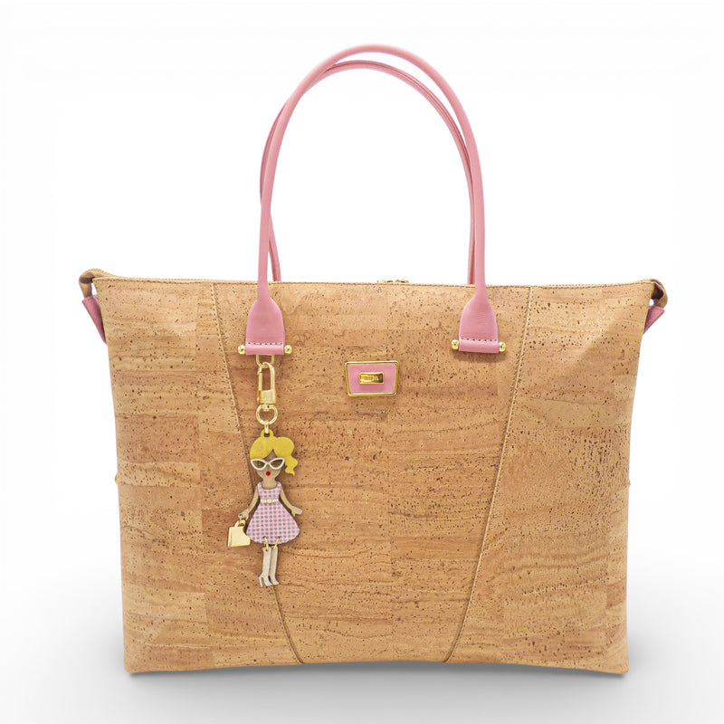 Grand sac convertible en liège naturel aux anses rose poudré, vu de face avec sa breloque poupée