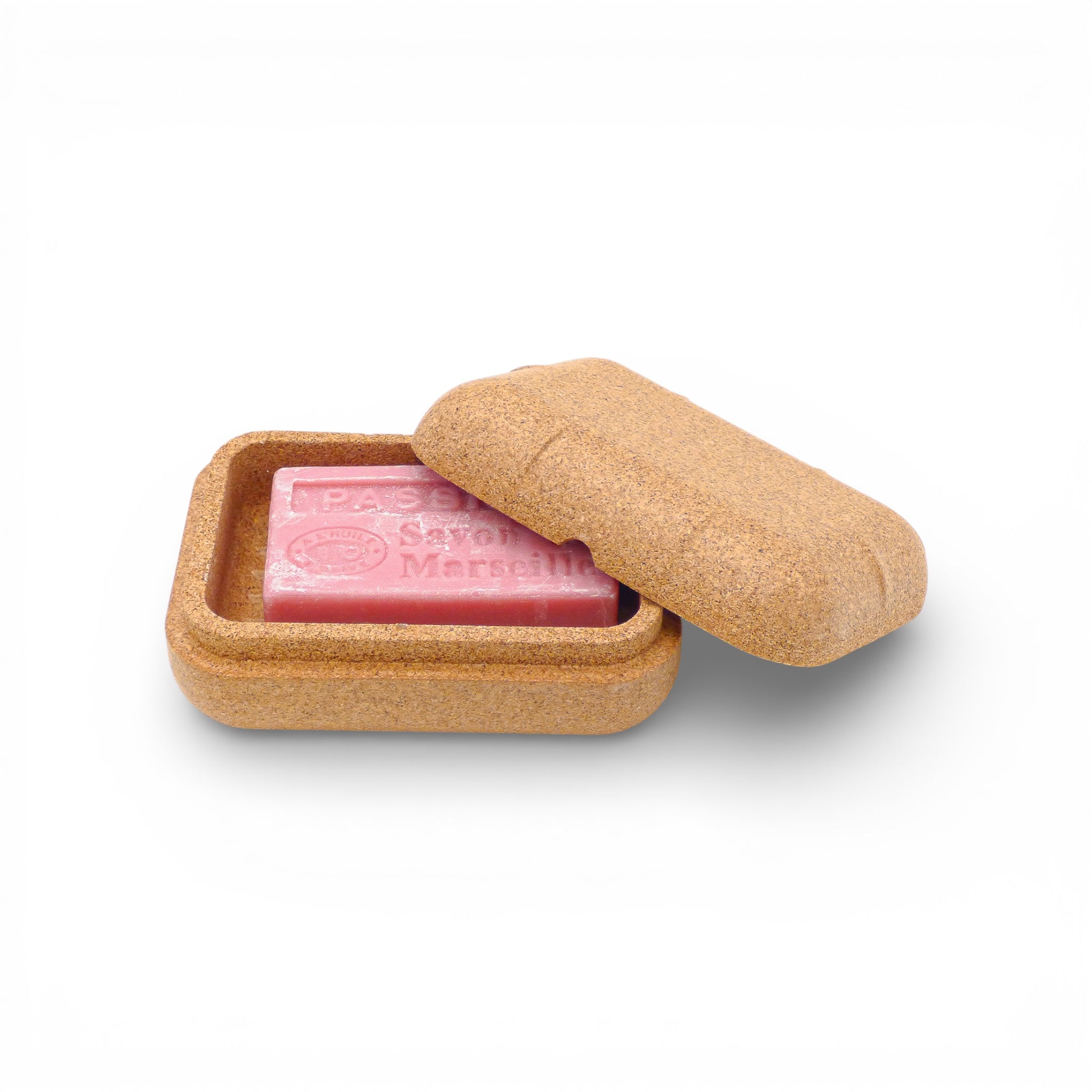 Boîte à savon entrouverte avec savon rose posé dans la cuve rainurée