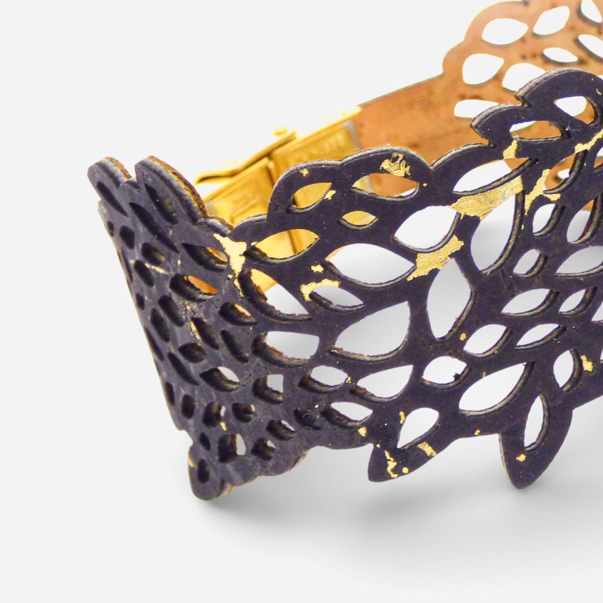 Black and gold leaf-patterned Cork Colors women's cork bracelet with cut-out design.