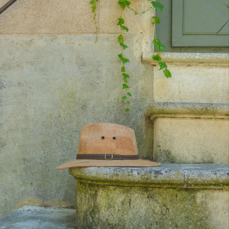 Chapeau cowboy en liège naturel posé sur un banc en pierre, décor de lierre — Amador Varum, ambiance extérieure, Portugal